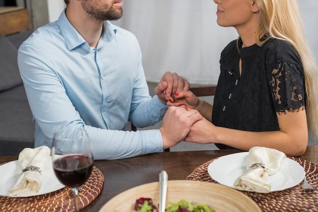 Close-up of a husband and wife holding hands across a dinner table, smiling at each other.