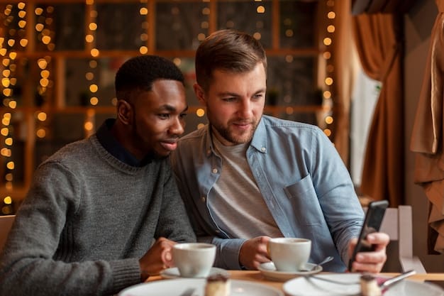 A man looking thoughtfully at his phone while his partner smiles reassuringly at him from across the table in a cozy café setting. The lighting is soft and intimate.