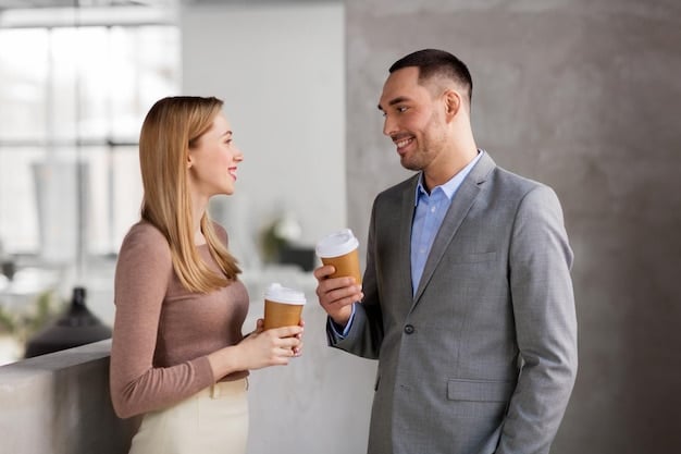 A husband and wife standing at a business social, the husband is offering a drink to the person he is speaking with and all three are smiling and engaged.