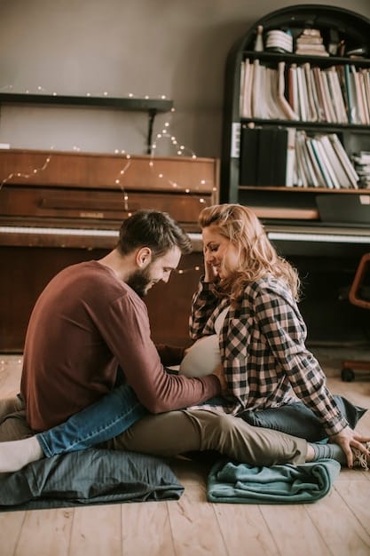 A couple sitting close together, holding hands, smiling and looking into each other's eyes, conveying connection and understanding. The setting is warm and intimate.