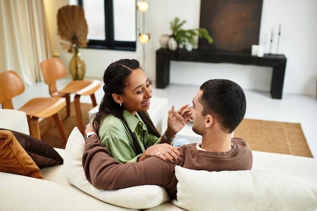 A couple sitting on a couch, smiling and looking into each other's eyes, with both their phones placed face down on a coffee table in front of them, symbolizing intentional disconnection from digital devices to foster real-life connection.