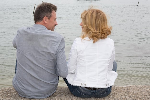 A couple sitting back-to-back, but with their hands gently touching, symbolizing mutual support and respect for individual space while maintaining connection.