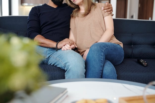 A couple sitting close together on a sofa, one partner gently touching the arm of the other, both looking thoughtful and engaged in a quiet, serious conversation, signaling intimacy and empathetic connection.