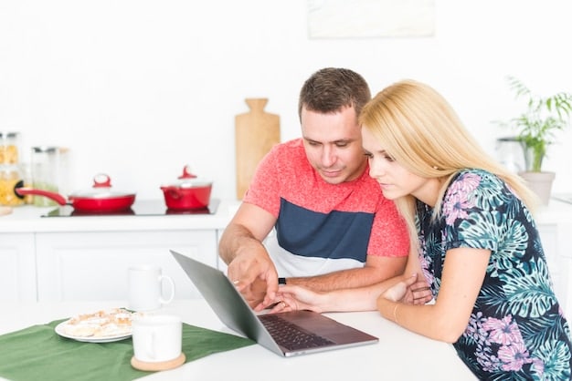 A couple sitting at a kitchen table, intently reviewing a laptop screen displaying a Social Security Administration website or a financial planning tool, with coffee cups, a pen, and a notepad nearby, suggesting a dedicated session of joint financial review and planning.