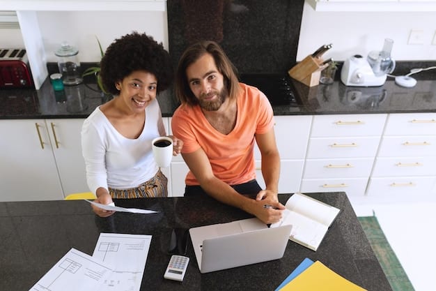 A diverse couple smiling and collaborating over financial documents at a kitchen table, symbolizing teamwork and shared financial goals.