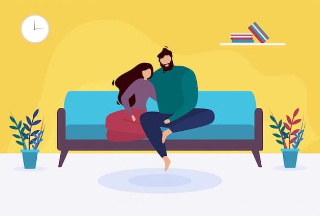 A couple sitting closely on a sofa, one person's hand gently resting on the other's lap, showing subtle but meaningful physical connection in a cozy home setting.