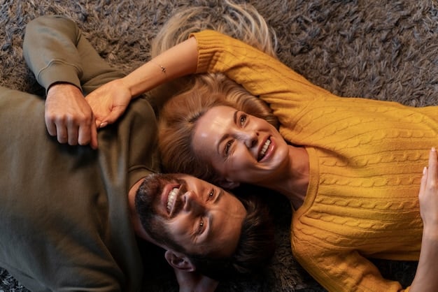 A couple laughing together, leaning into each other, showing genuine joy and connection through their facial expressions and body language, in a natural, softly lit setting.
